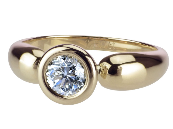 Ein eleganter goldener Ring mit einem glänzenden runden Diamanten in der Mitte
