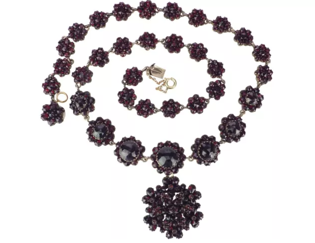 Dunkelrote Halskette mit auffälligen rund angeordneten Steinen und großem Anhänger