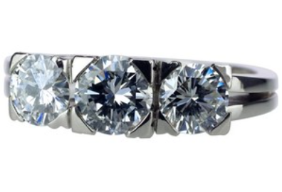 Ein silberner Ring mit drei funkelnden weißen Diamanten in moderner Fassung